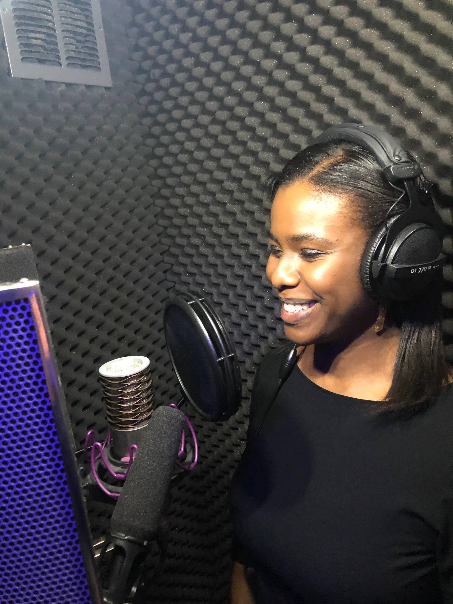 Maria Garcia recording at a studio microphone
