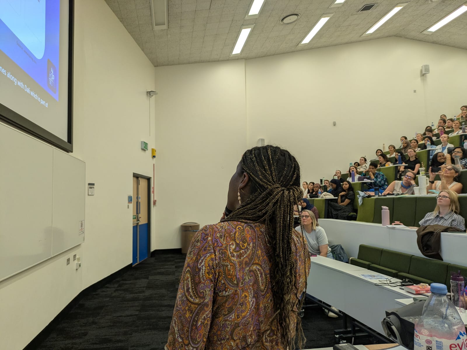Maria Garcia presenting to an auditorium audience
